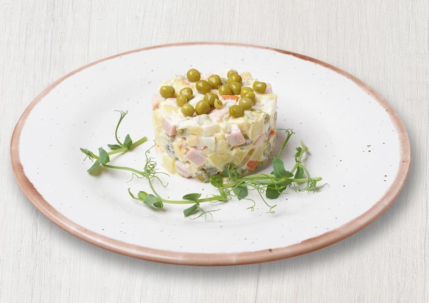 Russian salad with boiled vegetables and ham or chicken